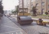 Jednou ze stavebních akcí letošních prázdnin týkající se městské dopravy v Brně byla i oprava tramvajové tratě na Jugoslávské ulici mezi křižovatkami s ulicemi Merhautovou a Helfertovou. Během tři týdny trvající výluky byl kompletně vyměněn kolejový svršek (a následně znovu zapanelován). Na dvou snímcích z 22. 7. 2002 je zachycen jednak stavební ruch během pokládky betonových pražců a jednak autobus náhradní dopravy evid. č. 7410 (linka č. 46), který právě vyjíždí ze zobousměrněné Hefertově ulici (od Merhautovy) na náměstíčko mezi Jugoslávskou a Lesnickou ulicí, foto © Ladislav Kašík. 